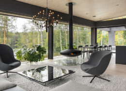 Hybridihirsitalo Villa Luxin olohuoneessa on suuret ikkunat ja roikkuva takka